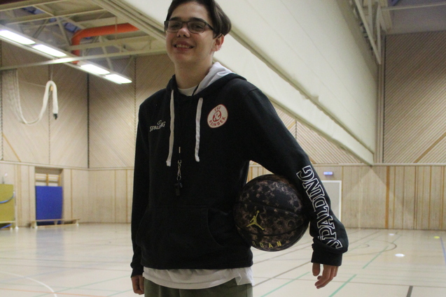 Portr&auml;t von Lucas Bliesener mit einem Basketball unter dem Arm in der Sporthalle.