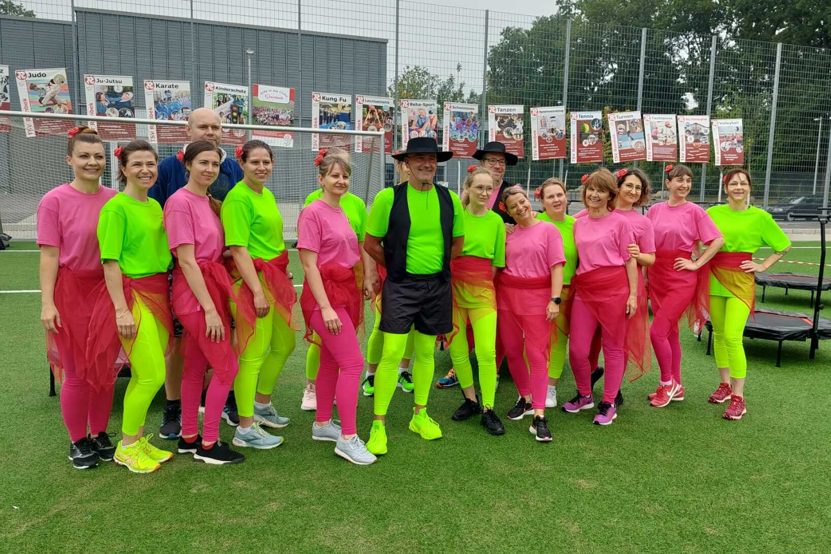 Trampolin Fitness Sportfest Gruppenbild der Trampolin-Fitness Gruppe in pinken und neongrünen Anzügen auf dem Sportfest