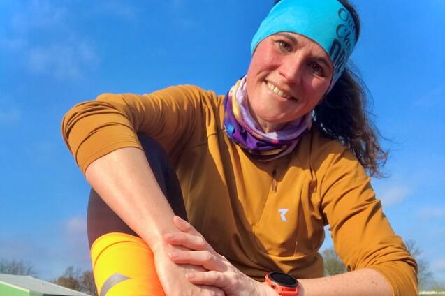 Verena Godersky in Sportkleidung sitzt auf der Tartanbahn