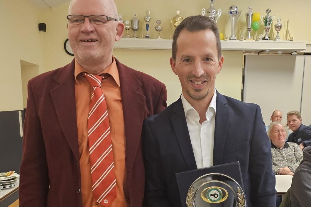 Dennis Krohn wird ausgezeichnet für 25-jährige Schiedsrichtertätigkeit 2 Männer in Anzug. Dennis Krohn präsentiert sein Auszeichnung