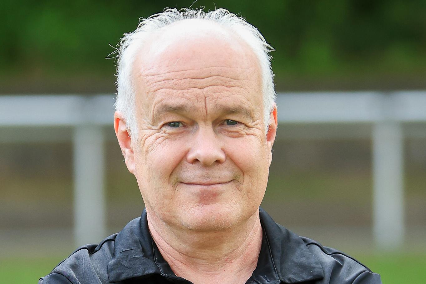 Portr&auml;tfoto von J&ouml;rg Wustrack, der, die Arme verschr&auml;nkt, in die Kamera schaut