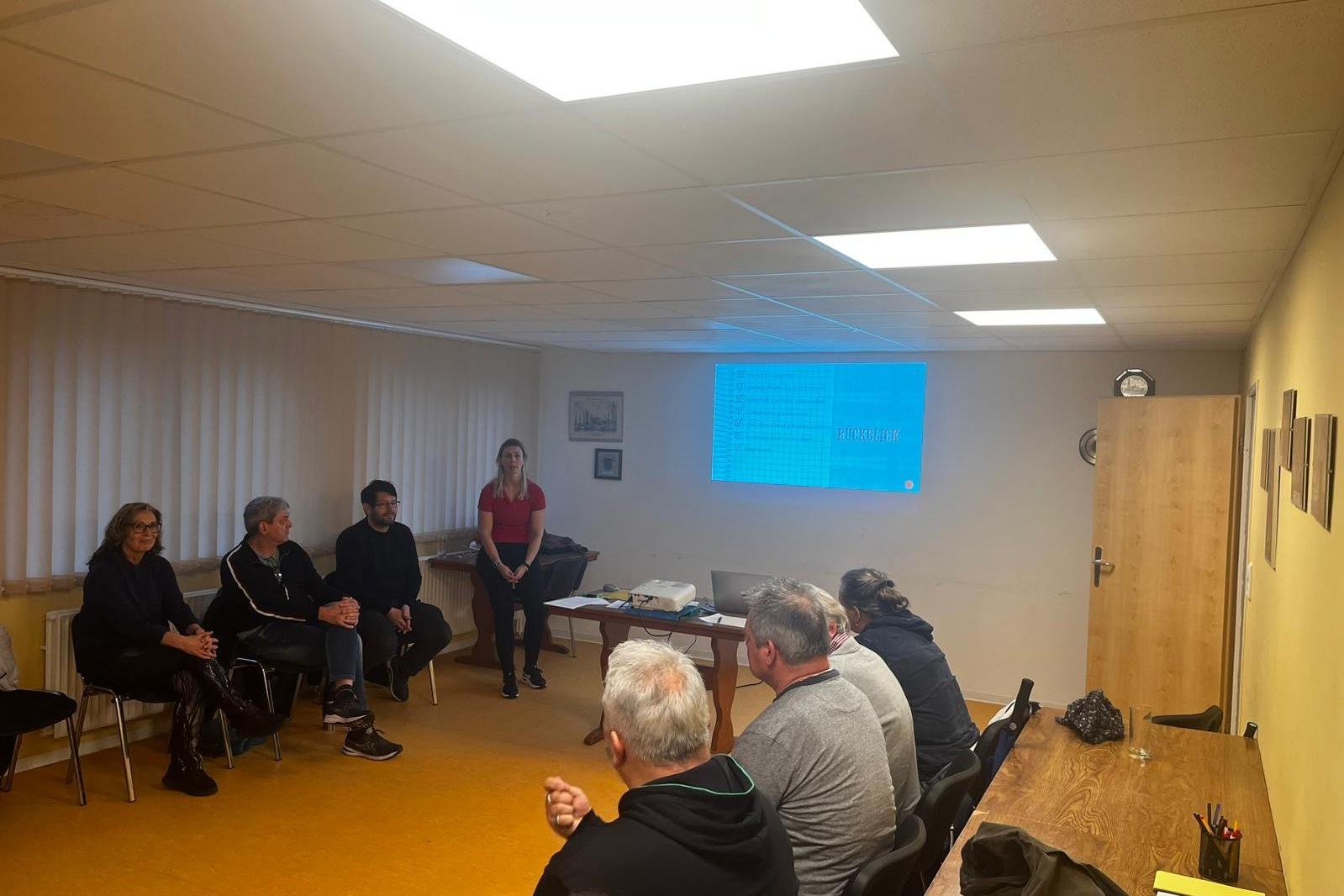 Ernährunsworkshop Personen sitzen im Stuhlkreis und die Referentin steht an der Präsentation.