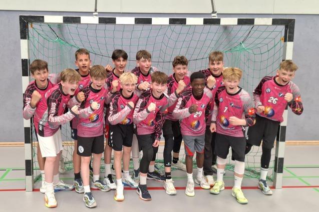 Jugendliche der Handballmannschaft stehen in einem Handballtor und jubeln