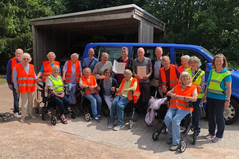 Gruppenfoto zur Ehrung der moin!Vereinshelden durch den Kreissportverband Stormarn Jens Deichmöller und Rainer Pommeranz prästentieren vor dem Bus umringt von den Teilnehmern der Rollatorgruppe stolz ihr Urkunden zur Auszeichnung zum moin!Vereinshelden