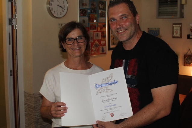 Die Gesch&auml;ftsf&uuml;hrerin des Kreissportverbandes Stormarn &uuml;berreicht unserem Abteilungsleiter Karate Timo Stieger-Fleischer die Ehrenurkunde im Clubhaus.