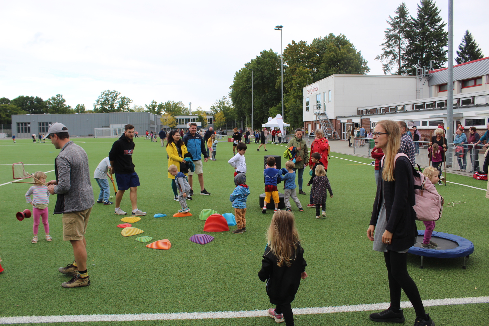 Kinder und Eltern probieren sich am diversen Kleinspielen zu Balance und Geschicklichkeit auf dem Kunstrasen.