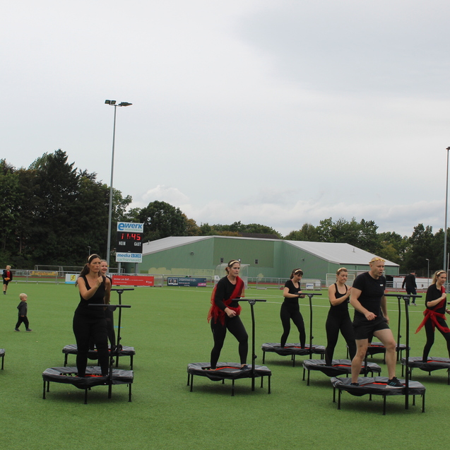 Die Trampolin-Fitness Gruppe bei einer Aufführung auf dem Kunstrasenplatz.