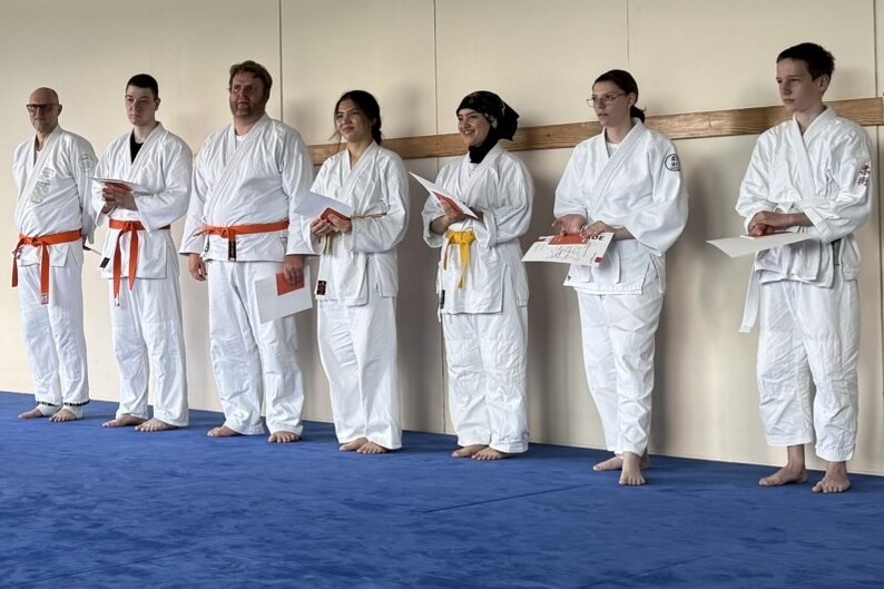 Ju-Jutsu Kämpfer stehen nebeneinander und halten Urkunden in den Händen