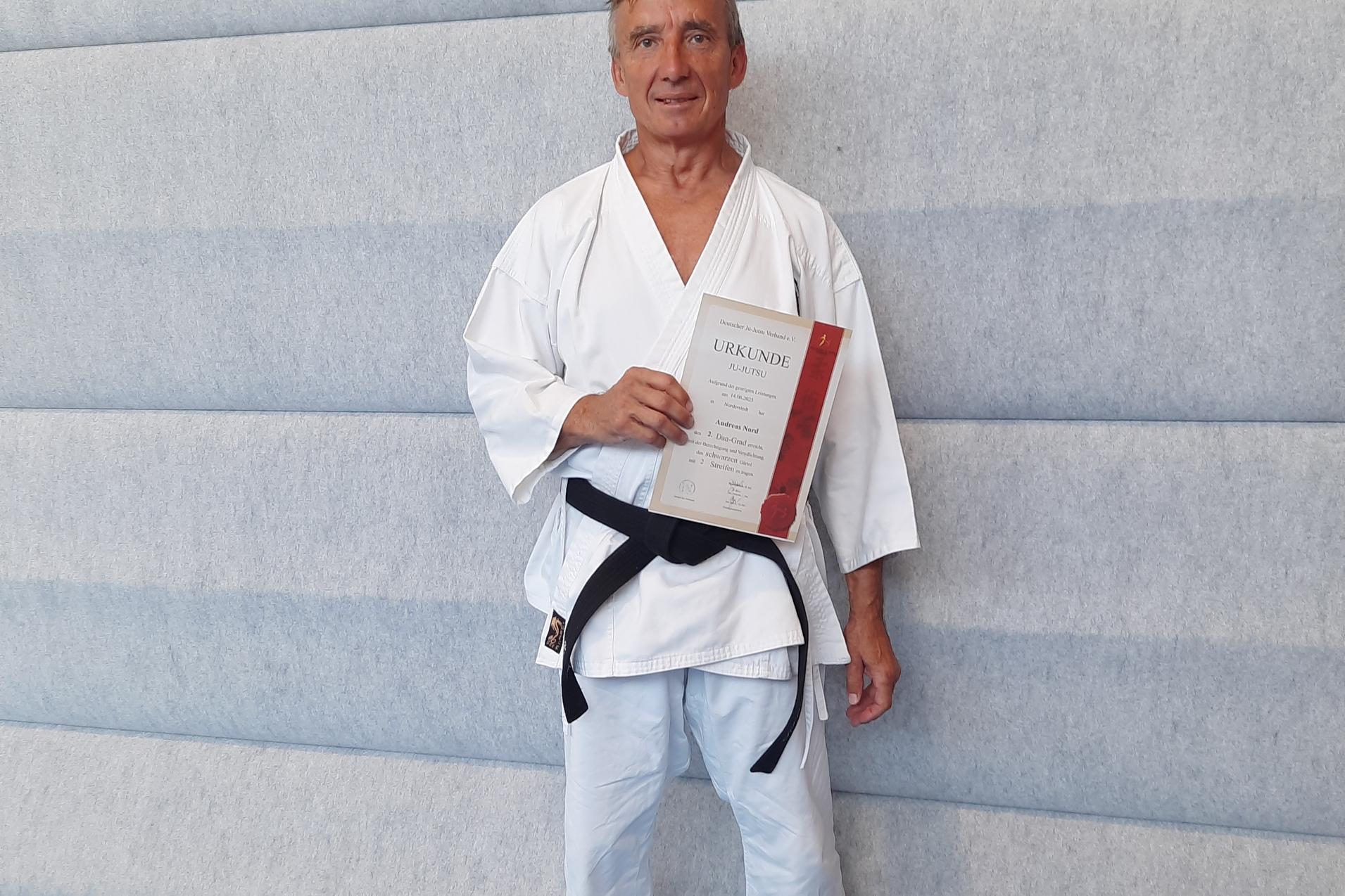 Andreas Nord Andreas Nord in Ju-Jutsu Kleidung präsentiert Andreas Nord die Urkunde zum 2. Dan
