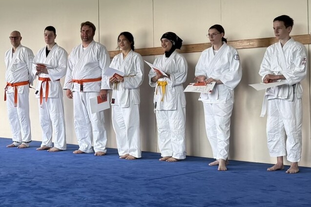 Ju-Jutsu Kämpfer stehen nebeneinander und halten Urkunden in den Händen