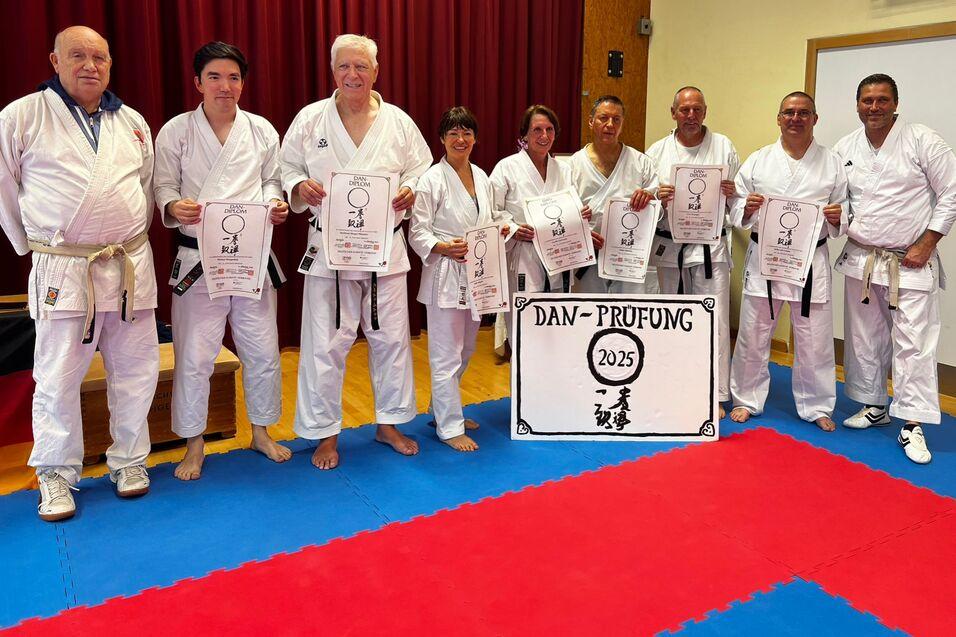 erfolgreiche Karateprüfungen Absolventen der nächsten Danauszeichnung stehen im Dojo und präsentieren ihre Urkunde