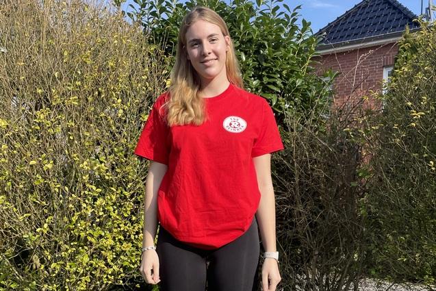 Hanna Behn vor einer Hecke.