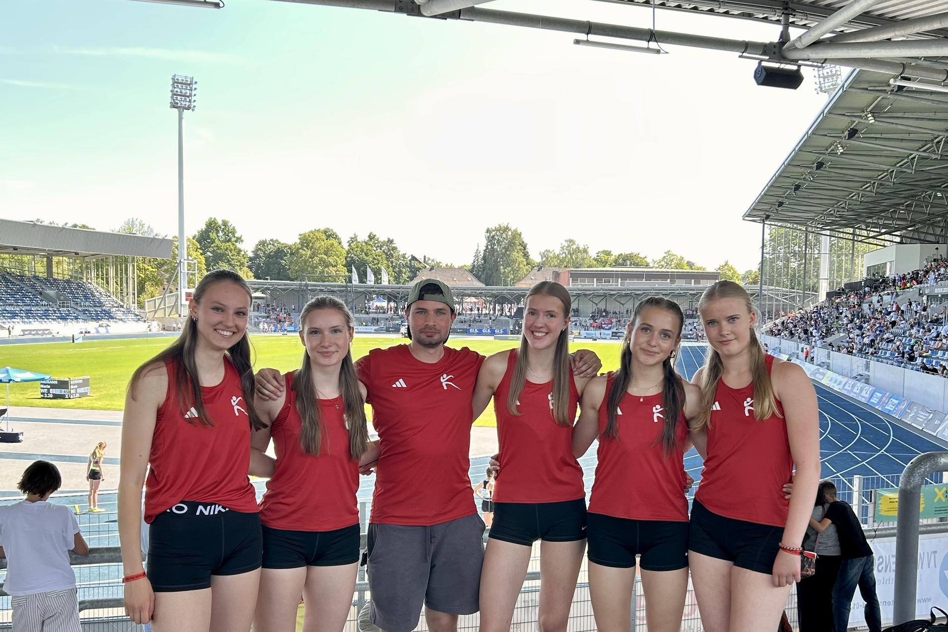 Leichtathletinnen posieren f&uuml;r ein Gruppenfoto im Stadion