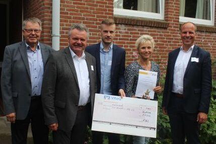Reha Post Covid Gruppe mit kleinem Stern in Bronze ausgezeichnet Gruppenbild von förmlich gekleidete Personengruppe hält Auszeichnung in die Kamera