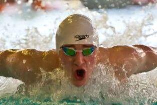 Schwimmer Schwimmer im Wasser mit weißer Badekappe und weit geöffnetem Mund.
