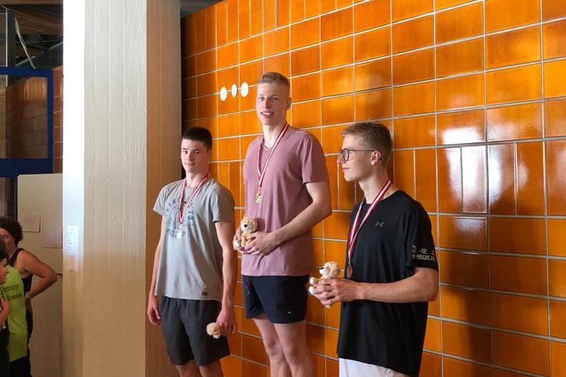 Erfolgreicher Saisonauftakt Drei junge Männer auf dem Siegerpodest.