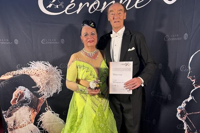 Ehepaar Hagemeister präsentiert in Turnier-Tanzkleidung ihre Urkunde