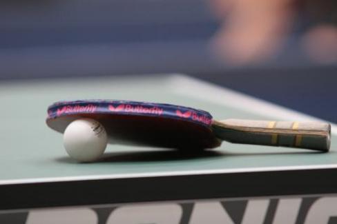 Tischtennisschläger mit Ball auf Platte