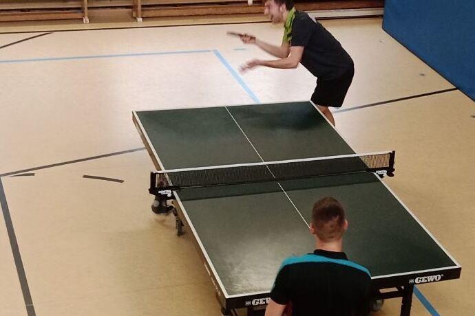 Zwei Spieler in Aktion an der Tischtennisplatte.