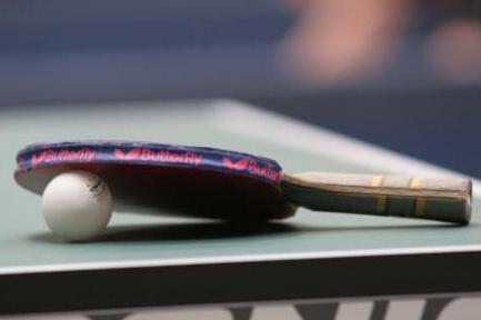 Tischtennisschläger mit Ball auf Platte