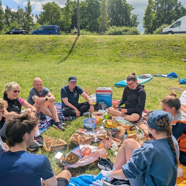 Probetriathlon 2026 Triathleten sitzen beim Picknick und Erfahrungsaustausch auf der Wiese.