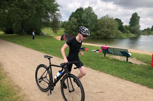 L&auml;ufer mit Fahrrad an der Hand in Bewegung