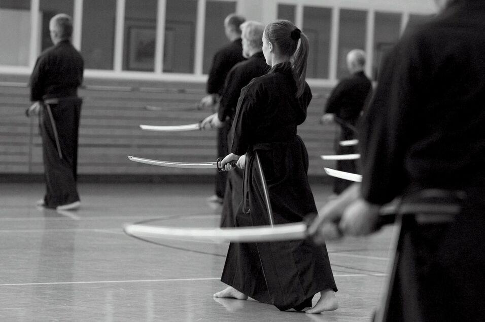Schwarz-wei&szlig; Bild. K&auml;mpfer stehen in der Halle im schwarzen Anzug