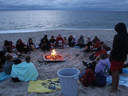 Zeltlager Lagerfeuer Die Gruppe des Zeltlagers sitzt am Strand um ein Lagerfeuer.
