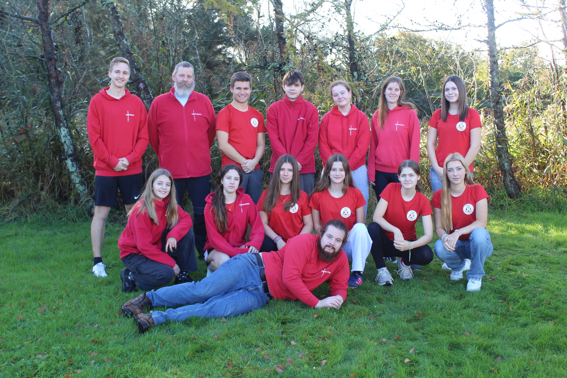 Die Mitglieder Vereinsjugend stehen zum Gruppenfoto auf einer Wiese vor Bäumen.