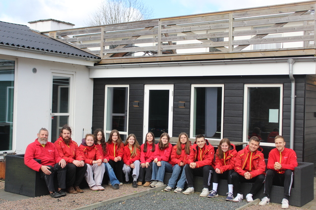 Teilnehmer des Fr&uuml;hlingsseminars sitzen in einer Sitzecke vor dem Haus
